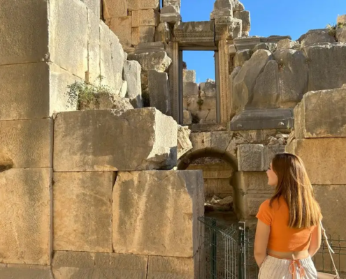 A visitor admires the detailed stone architecture of the ancient city of Myra, reflecting the grandeur of Lycian civilization