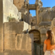 A visitor admires the detailed stone architecture of the ancient city of Myra, reflecting the grandeur of Lycian civilization