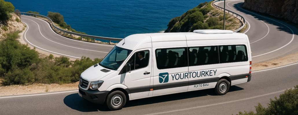 YourTourKey private transfer van driving along the coastal Finike road with a scenic Mediterranean backdrop