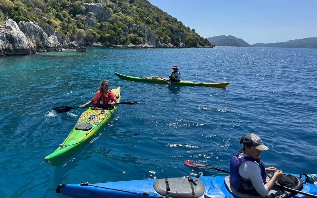Group of people kayaking in the blue waters of Kekova on a sunny day