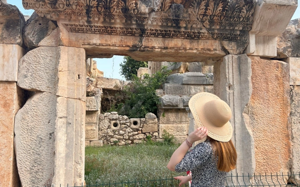 Visitors walking through the monumental Roman gate at Myra Ancient City, Demre