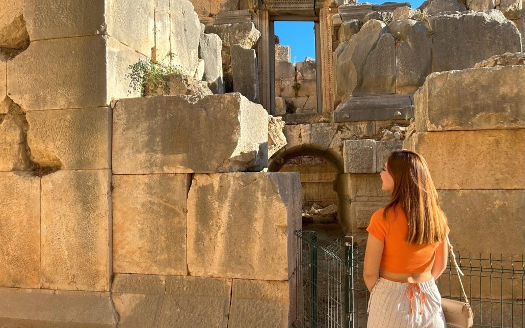 Female visitor exploring the ancient Lycian rock tombs at Myra Ancient City, Demre.
